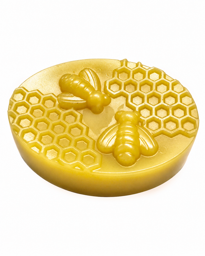 Oval golden beeswax wrap bar with raised bees and honeycomb pattern